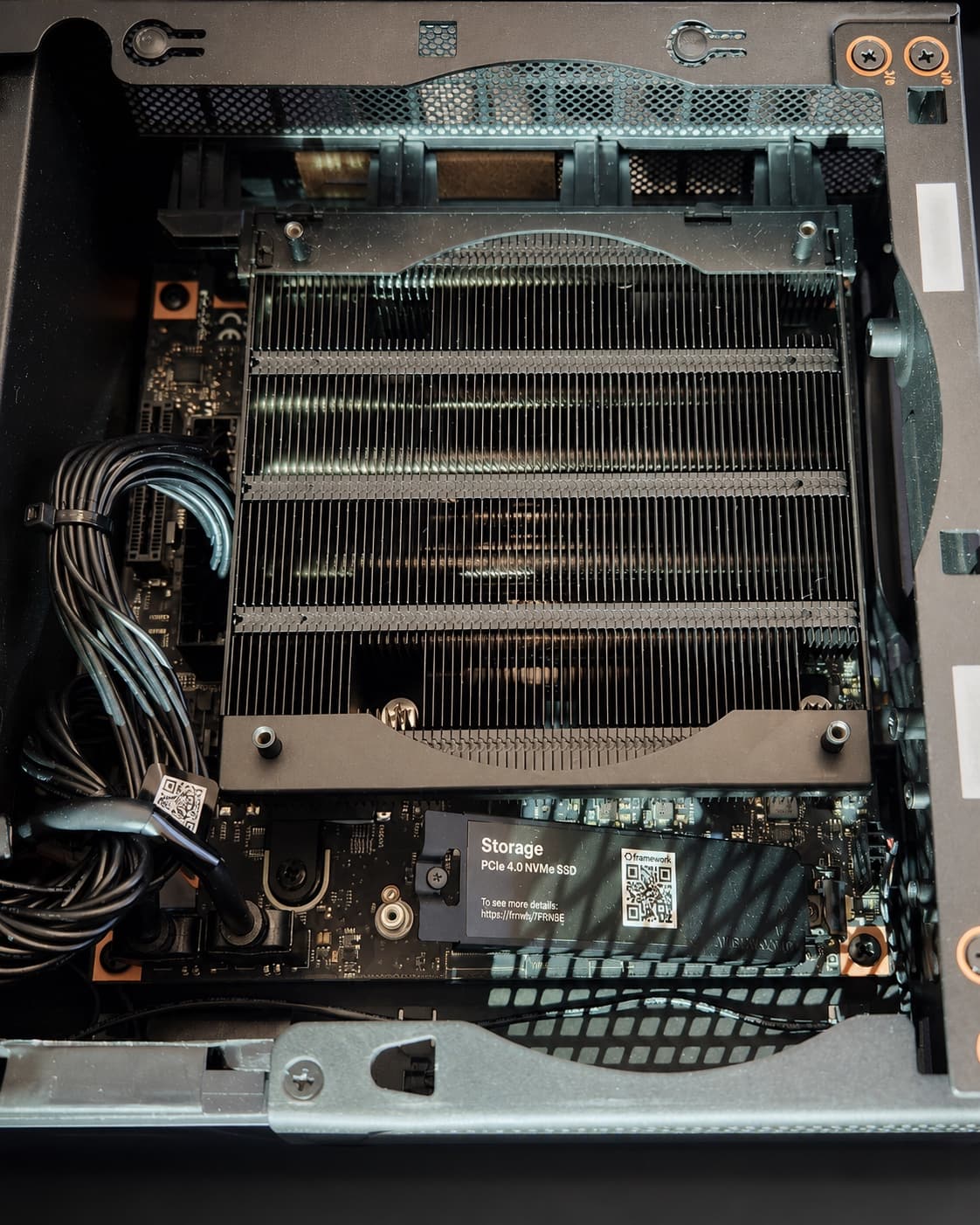 The open AMD Strix Halo system showing its heatsink, cabling, motherboard, and NVMe storage.