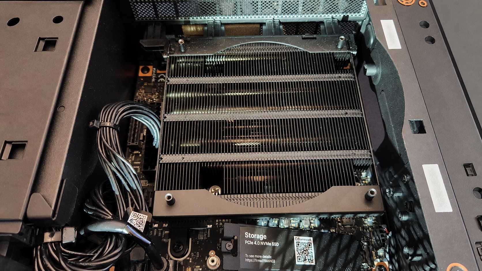 The open AMD Strix Halo system showing its heatsink, cabling, motherboard, and NVMe storage.